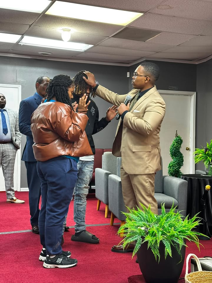 Elonzo praying with people at a ministry gathering